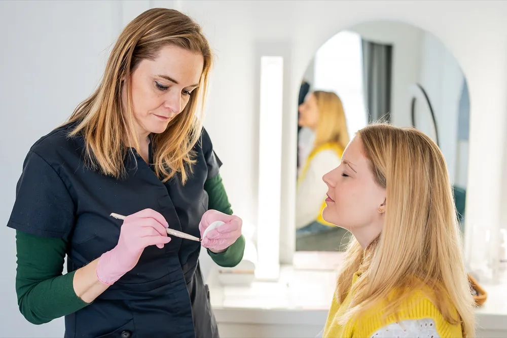 Patricia tekent de wenkbrauwvorm voor tijdens een behandeling